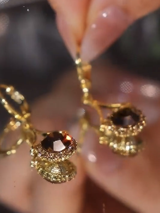 Elegantes pendientes marrones de metal redondo con microincrustaciones de diamantes